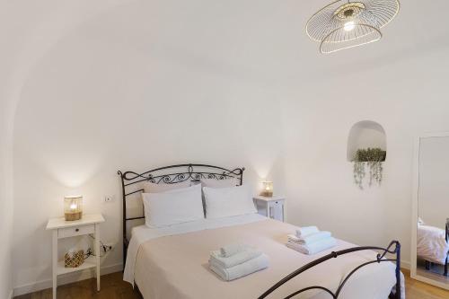 um quarto branco com uma cama com toalhas em Da I Ciarui Casa Vacanze em Dolceacqua
