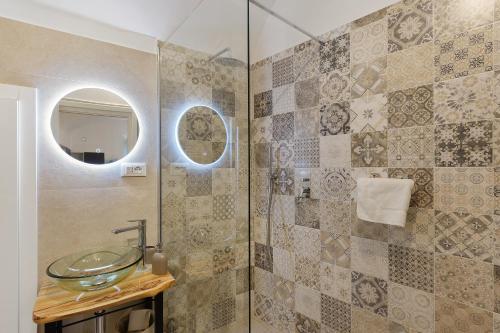 uma casa de banho com um lavatório de vidro e um chuveiro em Da I Ciarui Casa Vacanze em Dolceacqua