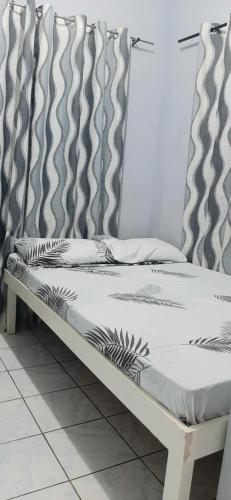 a bed sitting on top of a white floor at La Guerta Lodging House - Uno in Pintuyan