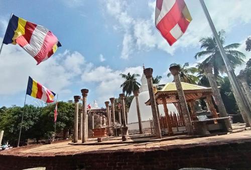 un grupo de banderas frente a un edificio en Hotel Galaxy, en Minneriya