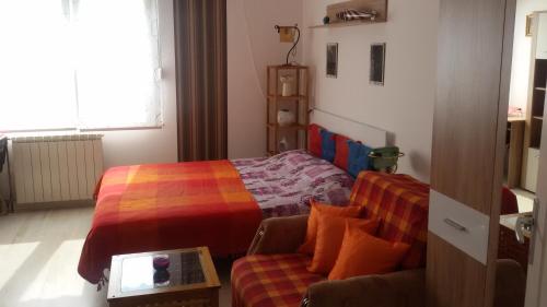 a small bedroom with a bed and a couch at Apartment Your second home in Subotica