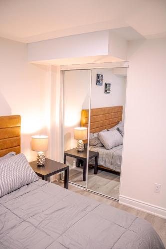 a bedroom with a bed and a mirror at Oshawa Two Bedroom Private Suite in Oshawa