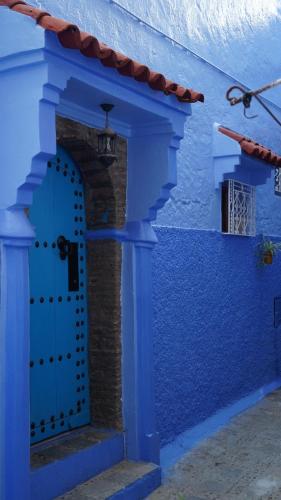 a blue building with a blue door at Dar Ouadie the pearl stay in Chefchaouen