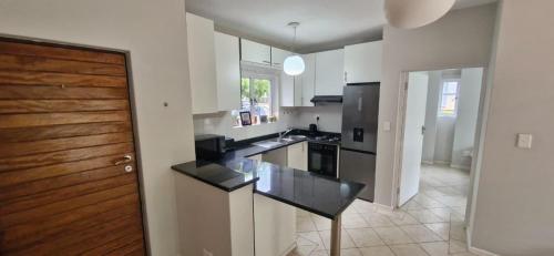 een keuken met een zwart aanrecht en een houten deur bij The Flip Flop Stop in Ballito