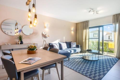 a living room with a table and a couch at Quinta do Algarvio Village in Carvoeiro