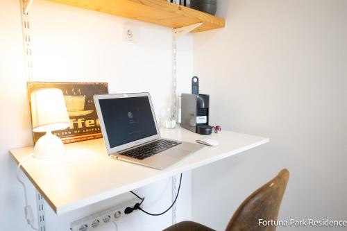 a laptop computer sitting on a white desk at Studio Fortuna Park Residence in Sfântu-Gheorghe