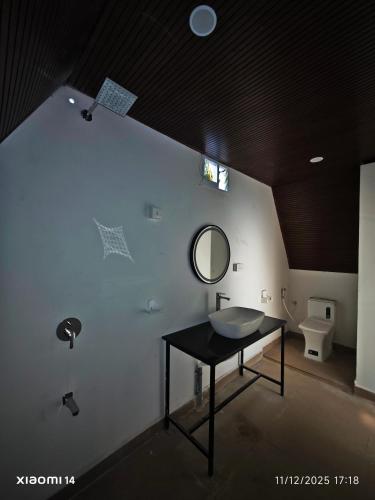 a bathroom with a sink and a mirror on a wall at Colomb Sea View Cottages in Patnem