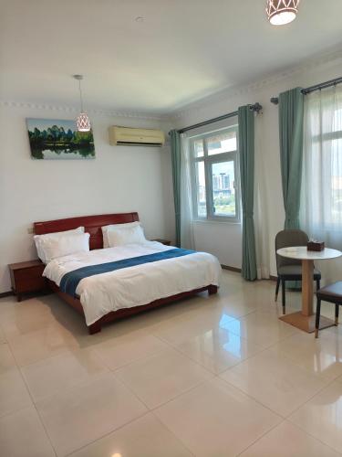 a bedroom with a large bed and a table at Zawadi Apartment in Dar es Salaam