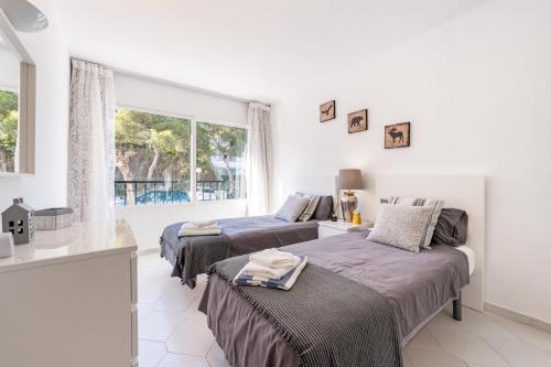 due letti in una stanza bianca con una finestra di Miraflores Luxury Duplex a Mijas Costa