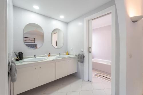 un bagno bianco con lavandino e vasca di Miraflores Luxury Duplex a Mijas Costa