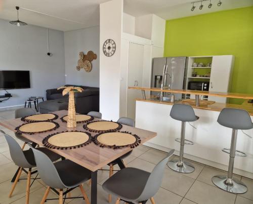 Maïlly - Charmante villa T5 avec piscine - Empire House في كابستر-بيل-أو: مطبخ وغرفة طعام مع طاولة وكراسي