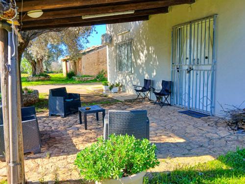 un patio con sedie e tavoli e una casa di Casa Tosca a San Pietro