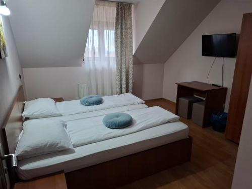 ein Schlafzimmer mit einem Bett mit zwei blauen Kissen darauf in der Unterkunft B&B Granada in Covasna
