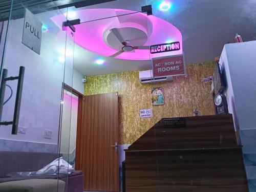 Una habitación con un ventilador de techo y una luz rosa. en Shree Girraj Dham Vrindavan, en Chhatikara