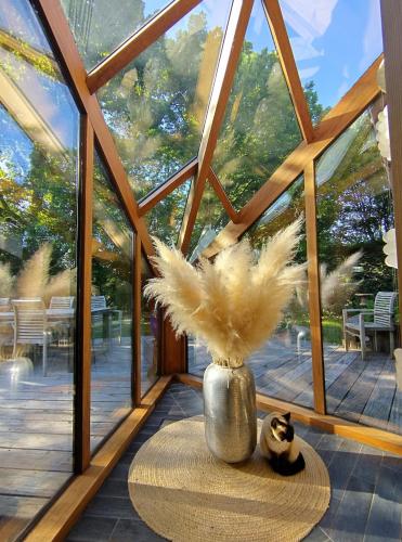 a glass house with a vase with feathers in it at Villa West heaven Valley Gent in Ghent