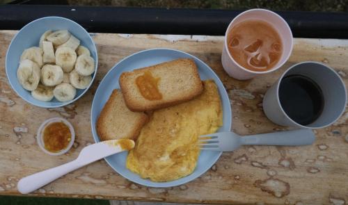 een bord eten met toast en bananen en een kopje koffie bij Villa Malibu in Santa Marta