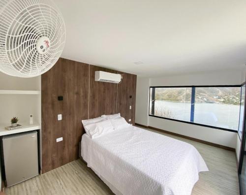 een slaapkamer met een wit bed en een groot raam bij Villa Malibu in Santa Marta