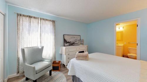 een slaapkamer met een wit bed en een stoel bij Oceanview Oasis Seaside Holiday Retreat in Old Orchard Beach