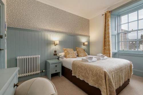 a bedroom with a bed with towels on it at The Albany St Andrews in St. Andrews