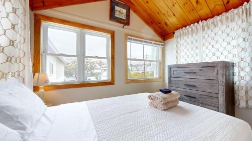 a bedroom with a white bed and two windows at Sand Life #2 by Bayley Vacation Rentals in Old Orchard Beach