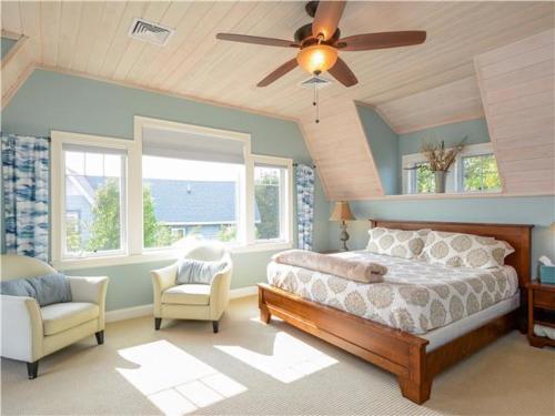 ein Schlafzimmer mit Bett und Deckenventilator in der Unterkunft Happy Holidays with Sea Breeze in Surfside