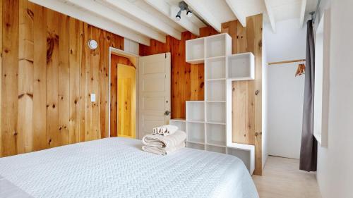 a bedroom with a white bed and wooden walls at Tide & Timber by Bayley Vacation Rentals in Old Orchard Beach