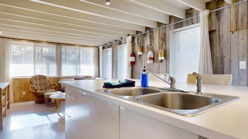 a kitchen with a stainless steel sink and windows at Tide & Timber by Bayley Vacation Rentals in Old Orchard Beach