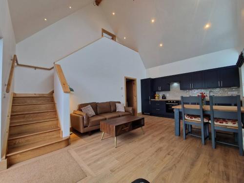 una sala de estar con un sofá y una mesa en Black Lodge - Sea view with deck garden, en Garrylucas
