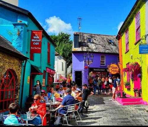 un grupo de personas sentadas en mesas en una calle en Black Lodge - Sea view with deck garden, en Garrylucas