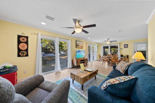 a living room with a blue couch and a ceiling fan at Bay Leave in Gulf Shores