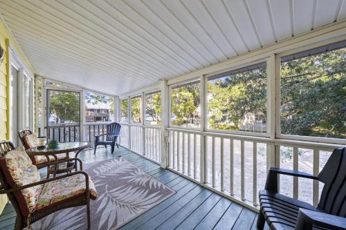 a screened in porch with chairs and a table at Bay Leave in Gulf Shores