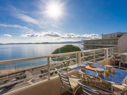 a balcony with a table and chairs and a view of the water at Vue Mer - Neuf - Centre Ste Maxime in Sainte-Maxime