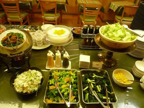 uma mesa com pratos de comida e tigelas de comida em Hotel Crown Hills Koriyama em Koriyama