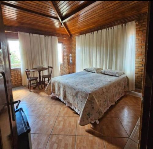 una camera da letto con un letto e un tavolo con sedie di Casa amanhecer a Triunfo