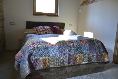 una camera da letto con un letto con una trapunta sopra di Al Foér Guesthouse ad Averara