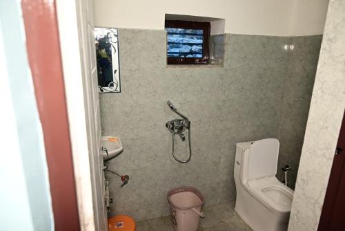 een kleine badkamer met toilet en douche bij Green View, devalsari in Dhanaulti