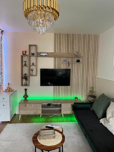 een woonkamer met een zwarte bank en groene verlichting bij Appartement Luxe - Smart Netflix & Alexa - 10 min La Défense 5 Guests 5 Beds in Bezons