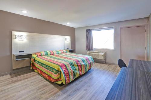 una habitación de hotel con una cama y una mesa en Super 7 Inn by Hotel O Dallas I 20, en Dallas