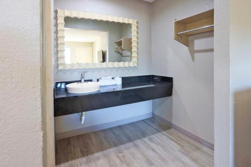 un baño con lavabo y espejo en Super 7 Inn by Hotel O Dallas I 20, en Dallas