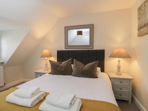 a bedroom with a large white bed with two lamps at Flat 6 in Tetbury