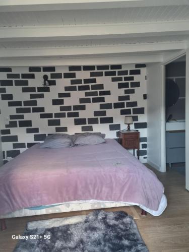 Chez Marilou في Arcens: غرفة نوم بجدار من الطوب باللونين الأبيض والأسود