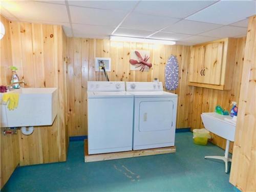 een badkamer met een wasmachine, een wastafel en een bad bij Sandy Beach at Star Board in Surfside