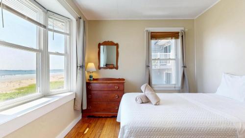een slaapkamer met een bed en een raam met uitzicht op het strand bij Sandy Beach at Star Board in Surfside