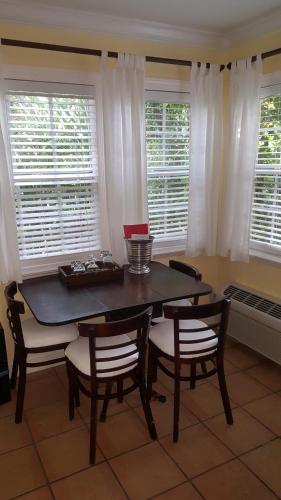 a dining room with a table and chairs and windows at The Caribbean Court Boutique Hotel in Vero Beach