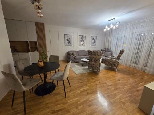 PARADISO STAN Bijeljina في بيه لينا: غرفة معيشة مع أريكة وطاولة وكراسي