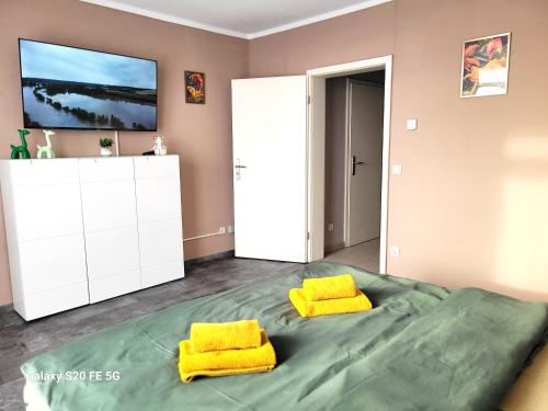 ein Schlafzimmer mit einem großen Bett mit zwei gelben Kissen in der Unterkunft Große 3-Zimmer Wohnung, zentrale Lage. in Mülheim an der Ruhr