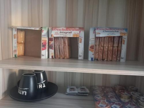 półka z książkami i czajnikiem na niej w obiekcie Mary&Bi w mieście Scalea