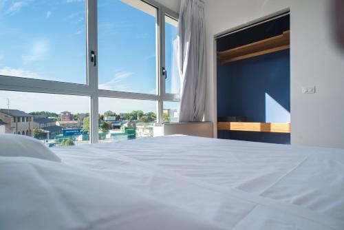 a white bed in a room with a window at Darsena Ravenna Apartments in Ravenna