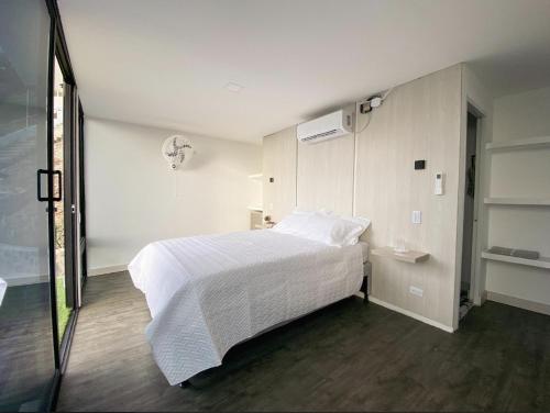 ein Schlafzimmer mit einem weißen Bett und einem Fenster in der Unterkunft Villa Malibu in Taganga