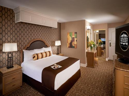 a hotel room with a bed and a dresser at Golden Nugget Hotel & Casino Las Vegas in Las Vegas